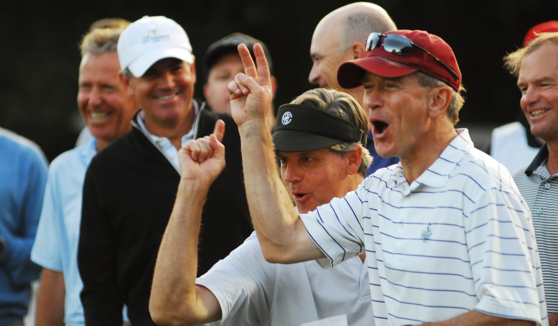 Four men celebrating enthusiastically outdoors.