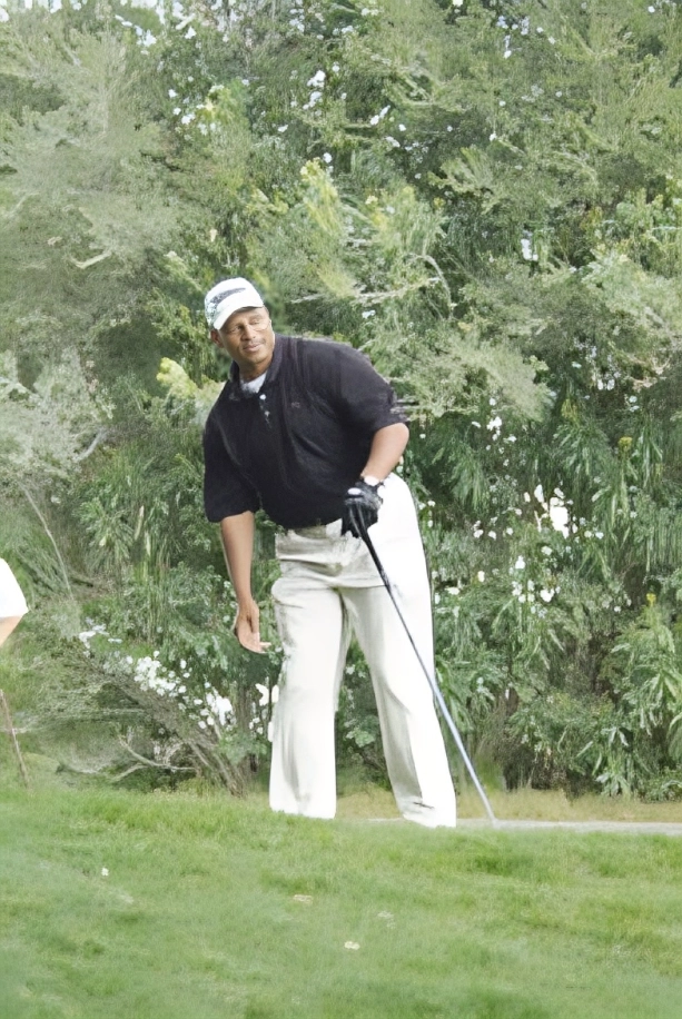 Man preparing to swing golf club on a green course.